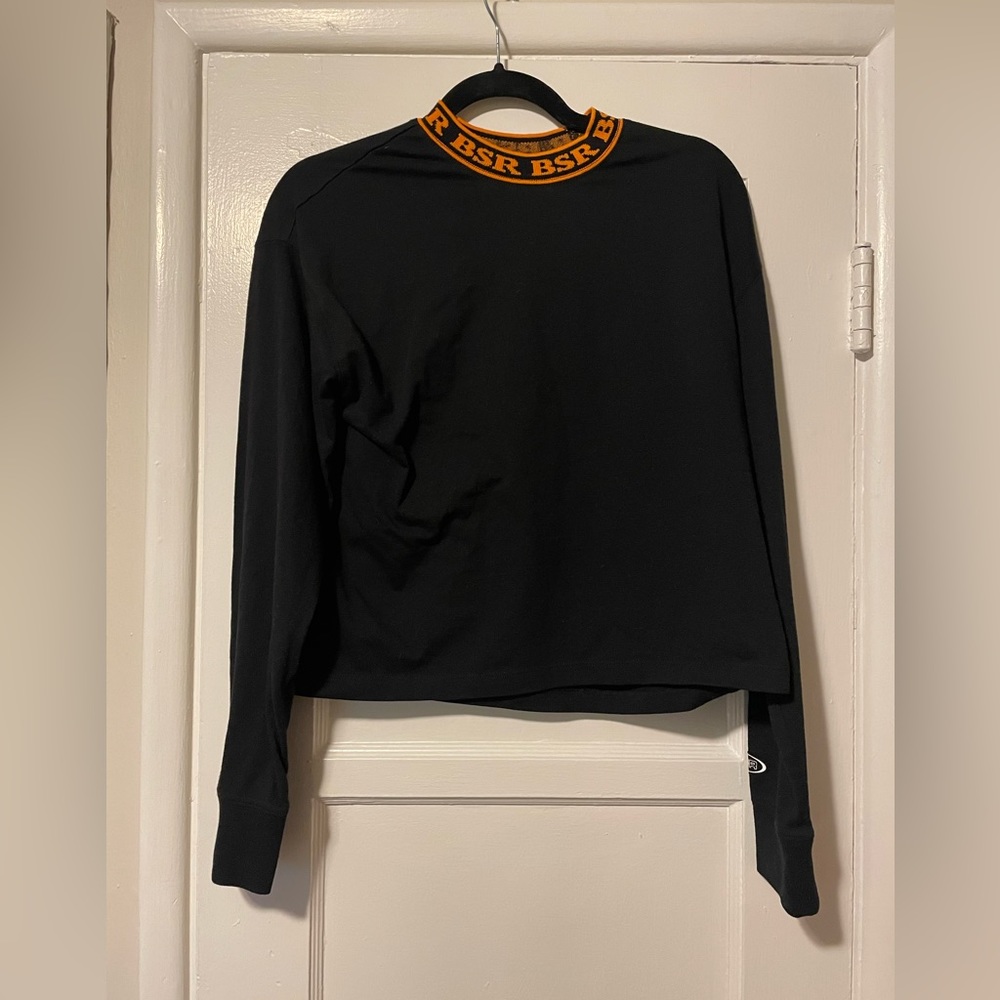 By Samii Ryan black long sleeve cropped tee with orange BSR logo collar. Small